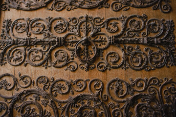 Metal ornament on the wooden door of the Catholic cathedral