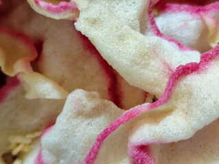 White rice crackers with bright pink accents, appetizingly displaying a crunchy texture, highlighting the crunchy and savory appeal of traditional Indonesian snacks.
