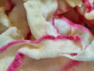White rice crackers with bright pink accents, appetizingly displaying a crunchy texture, highlighting the crunchy and savory appeal of traditional Indonesian snacks.