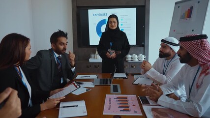 Western and emirati businesspeople in traditional arab attire participating in a conference with ceo, collaborating and taking notes in modern office environment