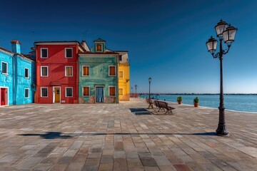 Fototapeta premium Colorful Venetian houses lining a waterfront plaza under a clear sky