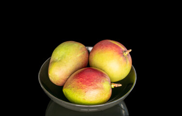 Ripe juicy mangoes on a black background, close-up.