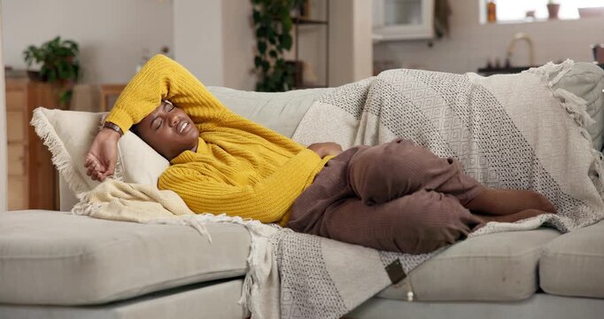Black woman, stomach pain and stress on sofa, home and exhausted with menstruation cramps in lounge. African person, belly ache and frustrated with constipation, digestion and burnout at apartment