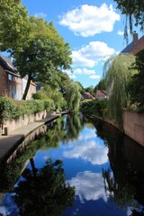 Fototapeta premium Landscape of canal weaving through old streets, peaceful and timeless
