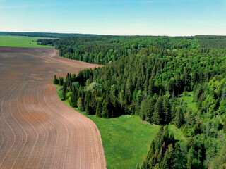 Aerial view landscape with plowed fields and forest on spring sunny day