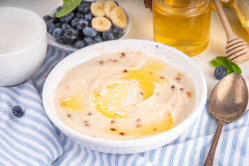Sweet breakfast farina porridge with butter, honey and fruits. American creamy milled wheat flour porridge, hot breakfast cereal
