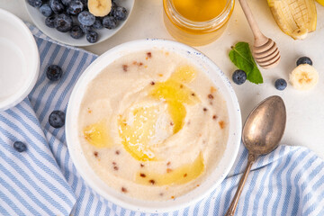 Sweet breakfast farina porridge with butter, honey and fruits. American creamy milled wheat flour porridge, hot breakfast cereal