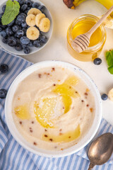 Sweet breakfast farina porridge with butter, honey and fruits. American creamy milled wheat flour porridge, hot breakfast cereal