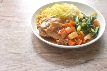 Chinese egg yellow noodles and cabbage with baking chicken gravy sauce on plate