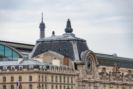 Close-up of the Orsay Museum's facade with the Eiffel Tower in the background, a view of two Parisian icons.