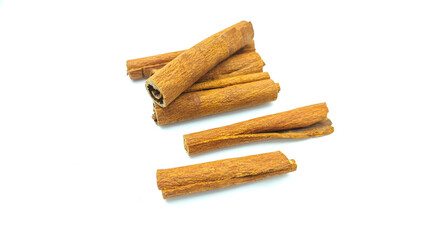 cinnamon sticks stacked on white background.