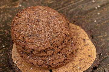 round chocolate biscuits with white sesame and cocoa powder, sweet chocolate-flavored biscuits with sesame seeds on the table, close up