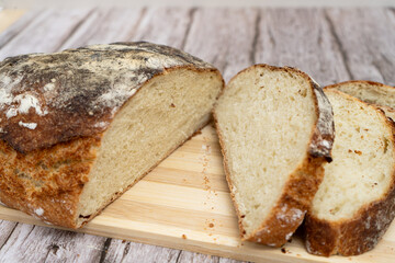 Sliced rustic homemade bread on wooden board