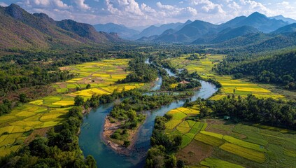 Aerial view of a winding river through a valley with rice paddies