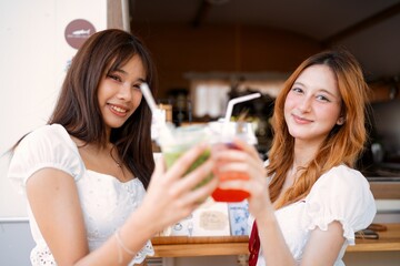 Friends celebrating at a cafe with refreshing drinks on a sunny day outdoors in a cheerful atmosphere