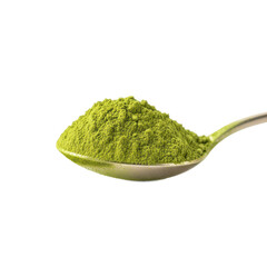A silver spoon holds a heap of vibrant green matcha tea powder, isolated on a white background.