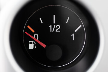 Car fuel gauge with pump pictogram, showing empty on fuel. Macro close up shot, no people