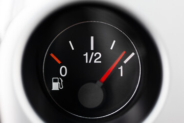Car fuel gauge with pump pictogram, showing close to full tank. Macro close up shot, no people