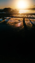 Light morning traffic on the river bridge as the sun shines brightly.