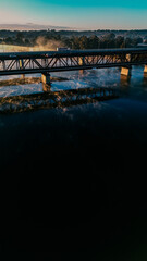 Rising morning mist under the river highway bridge.
