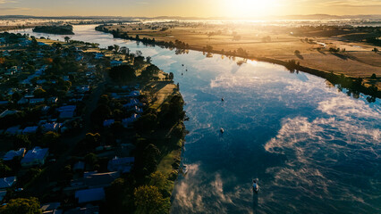 Aerial view of mist rising from the river surface as the morning sunshine heats up the landscape.
