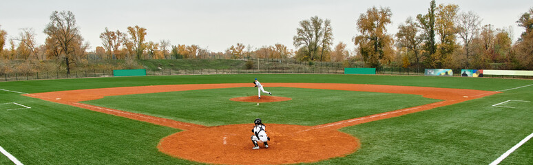 Teenage boys engage in spirited baseball game on a lush field in autumn