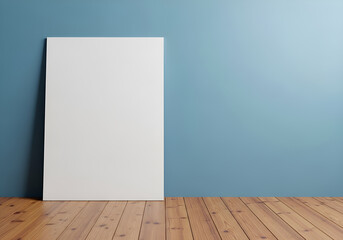 Blank white poster leaning against a textured blue wall on a wooden floor