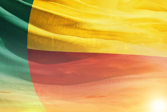 Benin national flag waving in sunny sky with beautiful sunset. Benin national flag for independence day.