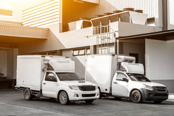 Refrigerated pickup trucks are parked in front of the factory, transporting frozen goods. © funfunphoto