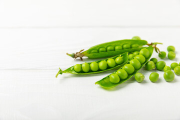 Fresh green pea pods with green peas on a wooden background. Sweet green peas. Green pea beans vegetables. Vegan. healthy vegetable. Copy space