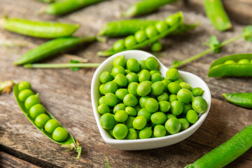 Fresh green pea pods with green peas on a wooden background. Sweet green peas. Green pea beans vegetables. Vegan. healthy vegetable. Copy space