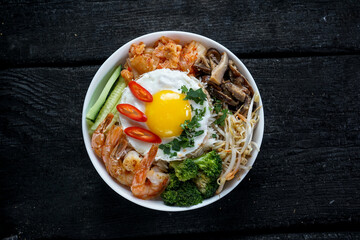 bowl with sprouts, shrimp, peppers, mushrooms and broccoli in a white plate