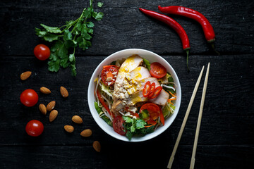 bowl with sprouts, fish, pepper and beans in a white plate on a black background with decor