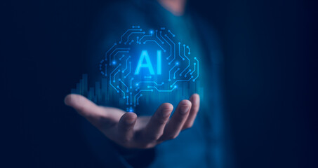 Artificial Intelligence and Technology. A hand holds a glowing brain circuit board with the AI, symbolizing the integration of AI technology and machine learning into business and future innovation.