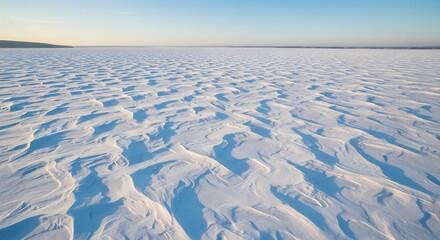 Golden Light on Rippled Snowdrifts Across a Vast Frozen Landscape.