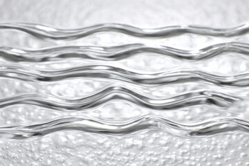 Abstract flowing water surface with rhythmic waves creating a clear, clean liquid background.