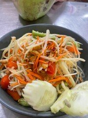 Thai papaya salad Som Tum with fresh vegetables and peanuts