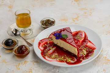 strawberry cheesecake dessert on a plate on a background with tea