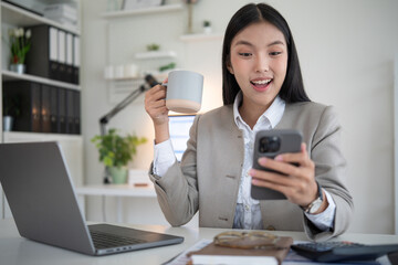 Excited businesswoman reacting to unexpected news on her phone during coffee break.