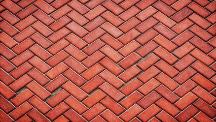 A Detailed View of Interlocking Red Brick Pavement Showing a Herringbone Pattern