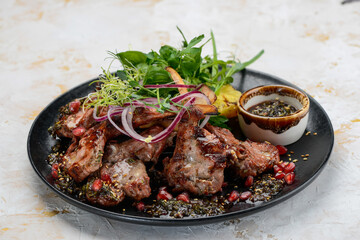 fried kebab in meat kare on a plate with green onions and sauce on the background