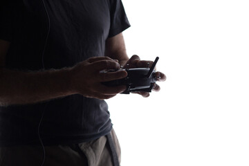 man holding in hands remote control of flying quadcopter, silhouette studio shot of modern human hobby and technology