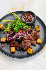 fried kebab on a plate with green onions and sauce