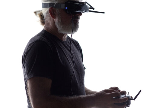Bearded senior pilot with FPV goggles and drone controller on white isolated background, modern male hobby and technology