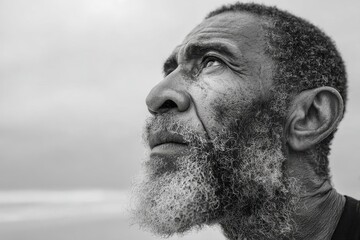 Fototapeta premium Thoughtful black and white portrait of an elderly man looking upwards.