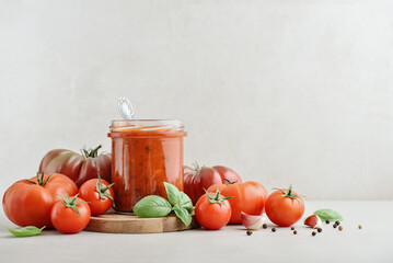 Traditional tomato sauce in a glass jar with fresh basil