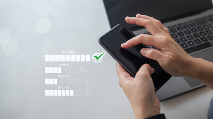 Close-up of hands using smartphone with multiple loading bars and a green check mark icon, representing mobile app progress, system update, task completion, and digital user interface concept.