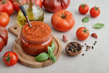 Traditional tomato sauce in a glass jar with fresh basil