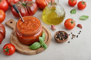 Traditional tomato sauce in a glass jar with fresh basil