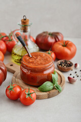 Traditional tomato sauce in a glass jar with fresh basil